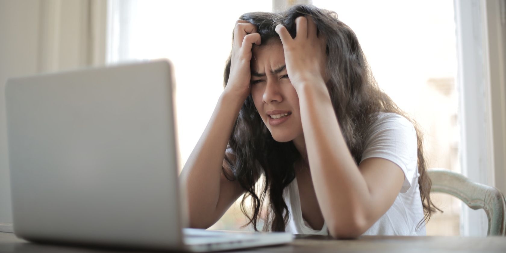 Woman showing frustration while using a laptop