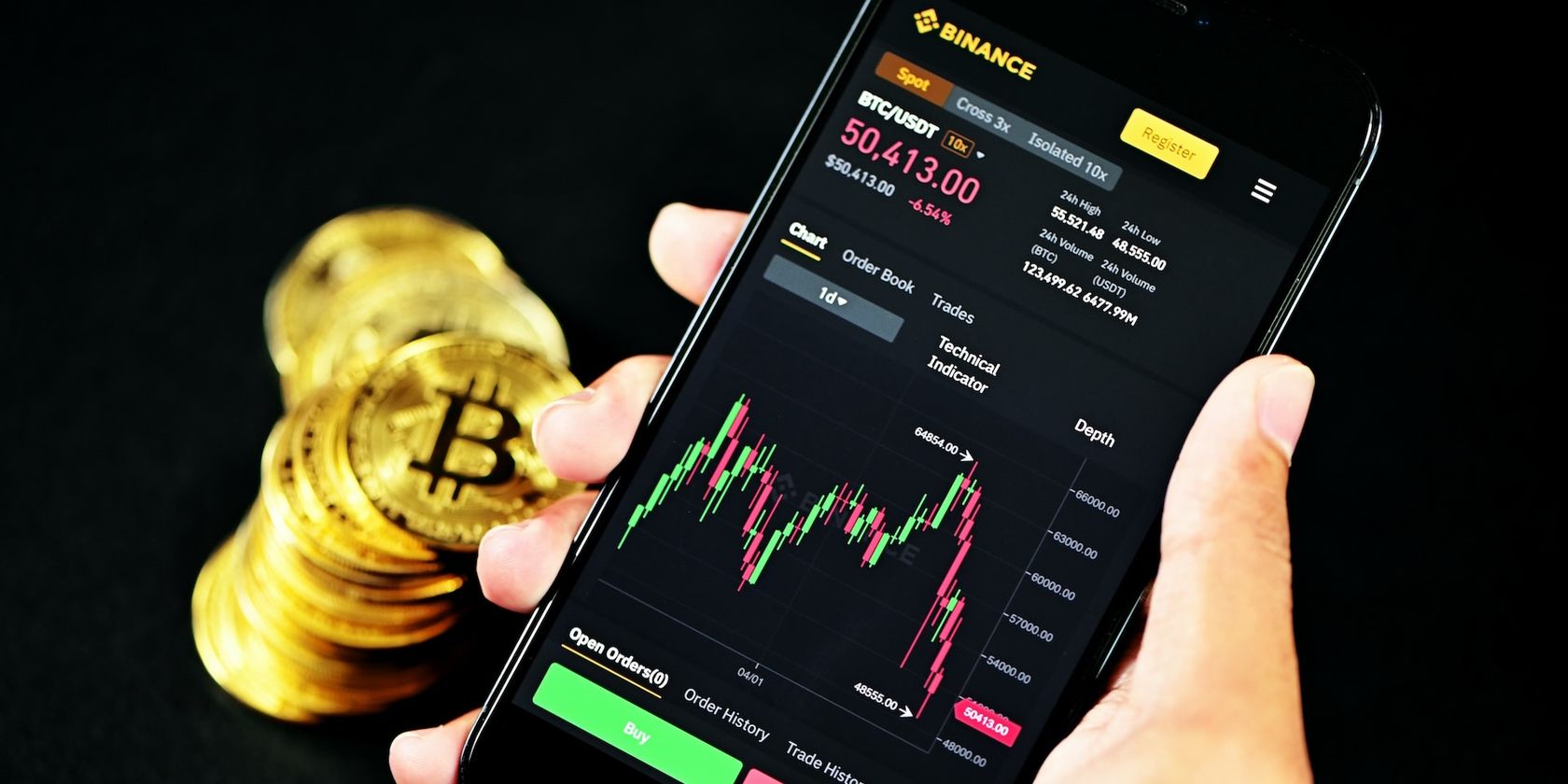 a picture of a hand carrying a phone with binance chart