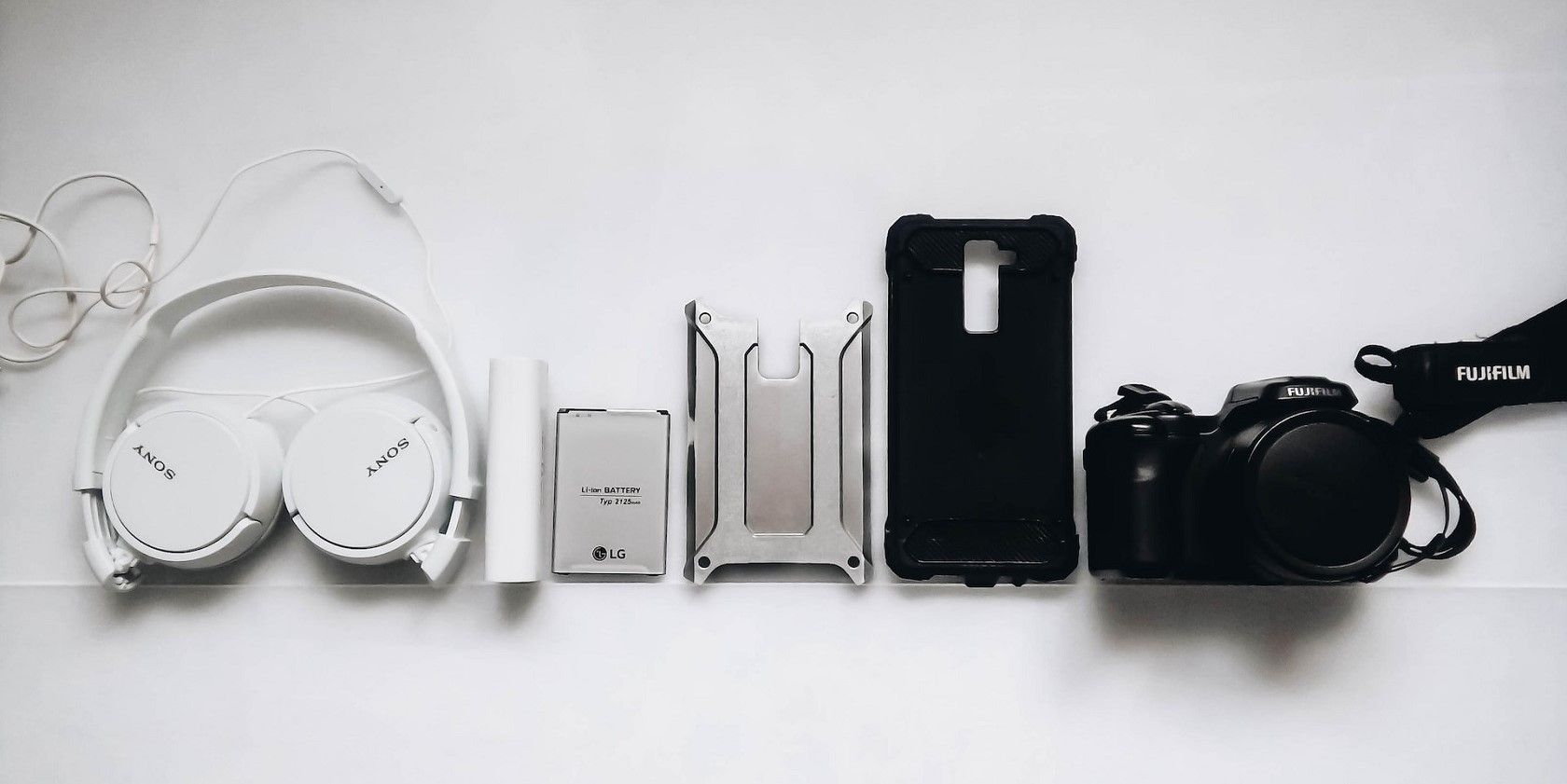 A Sony headphone, a Fujifilm camera, a phone case, and a few other accessories 
