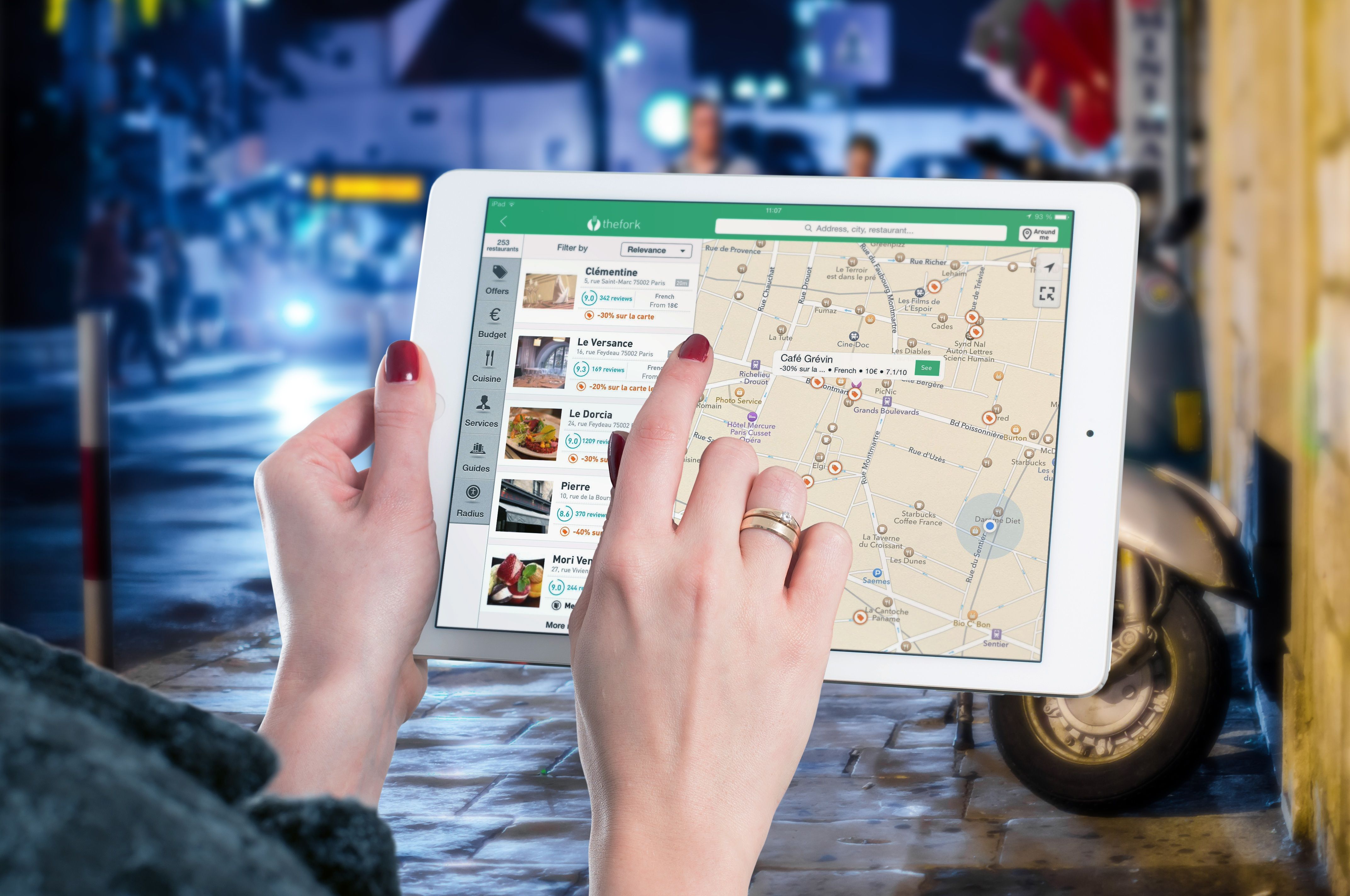 A woman using The Fork app on her iPad to find nearby restaurants in Europe