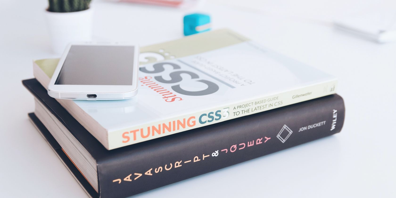 Two books about web development with CSS and JavaScript sitting on a table.