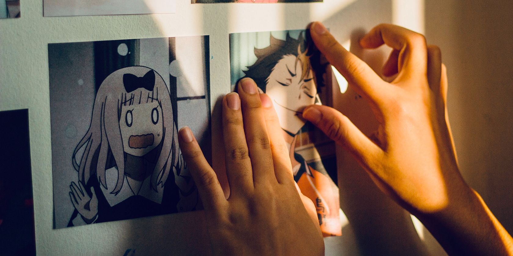 Person sticking up manga drawings on the wall