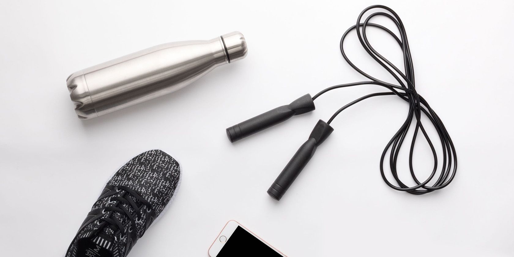 Jump rope, sneaker, and smartphone flat lay