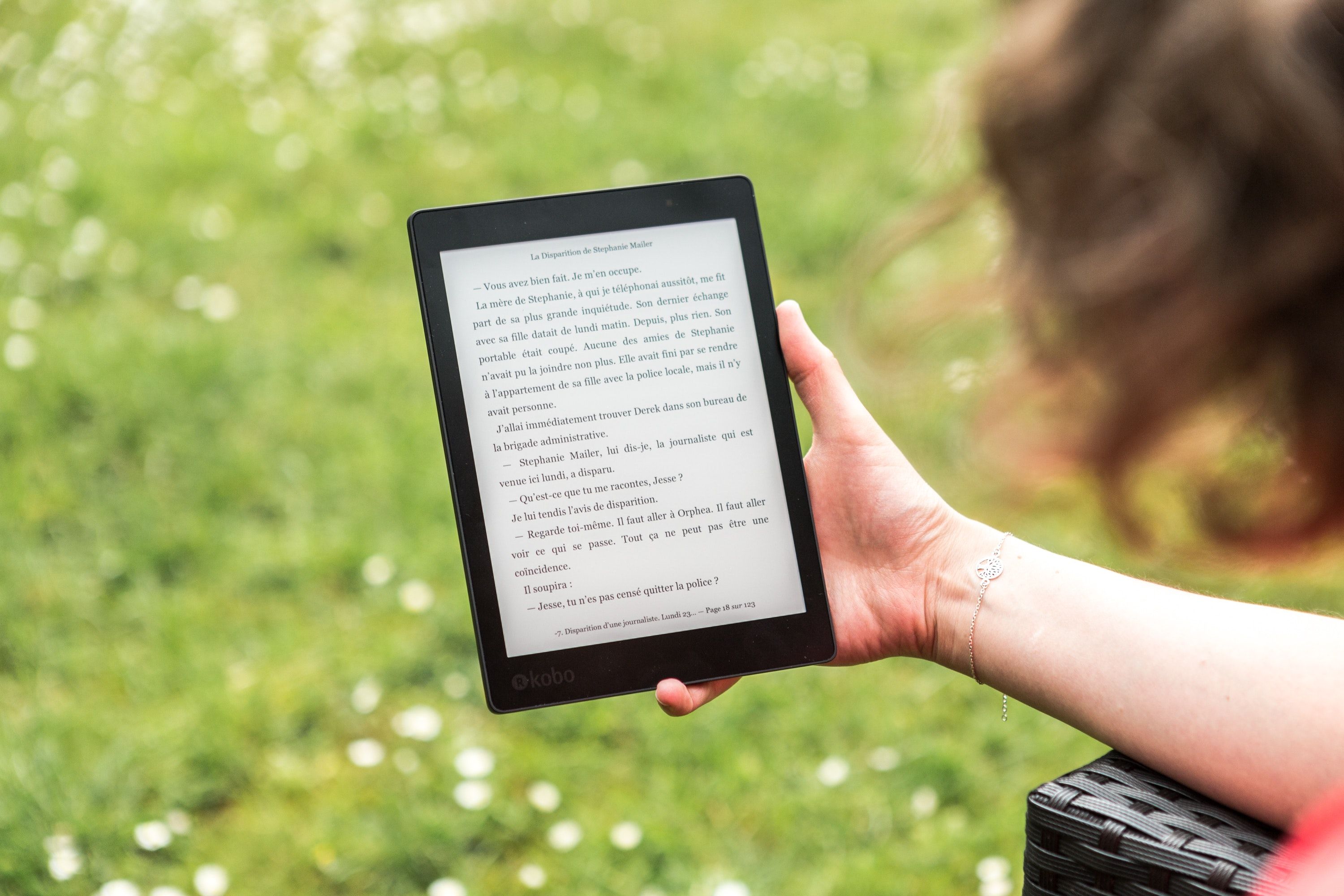 Perangkat Kindle melawan rumput di luar ruangan