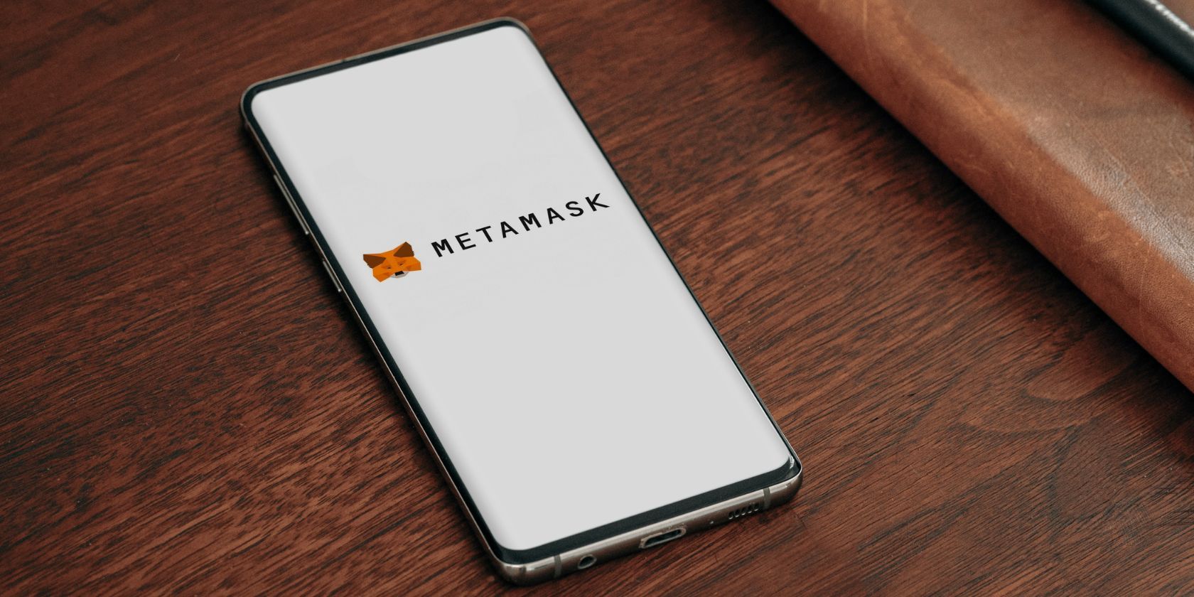 smartphone on desk with metamask app open on screen