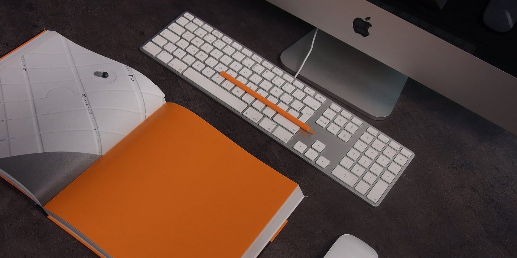 Orange book open in front of an iMac