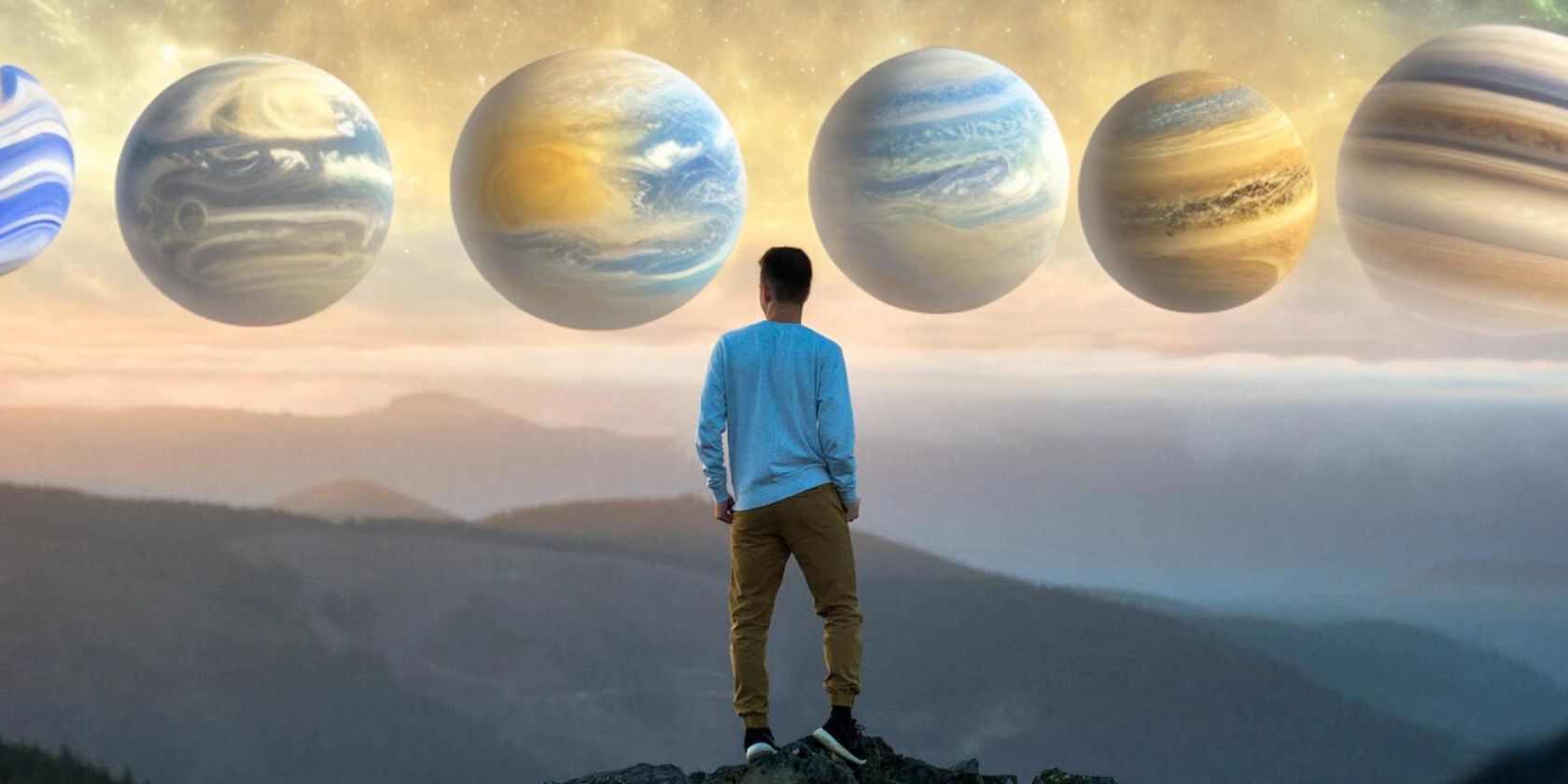 Man standing on top of mountain looking at planets in the sky
