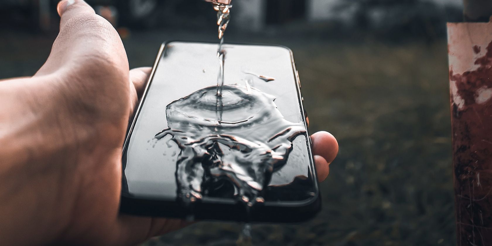 Verter agua en la pantalla de un teléfono inteligente