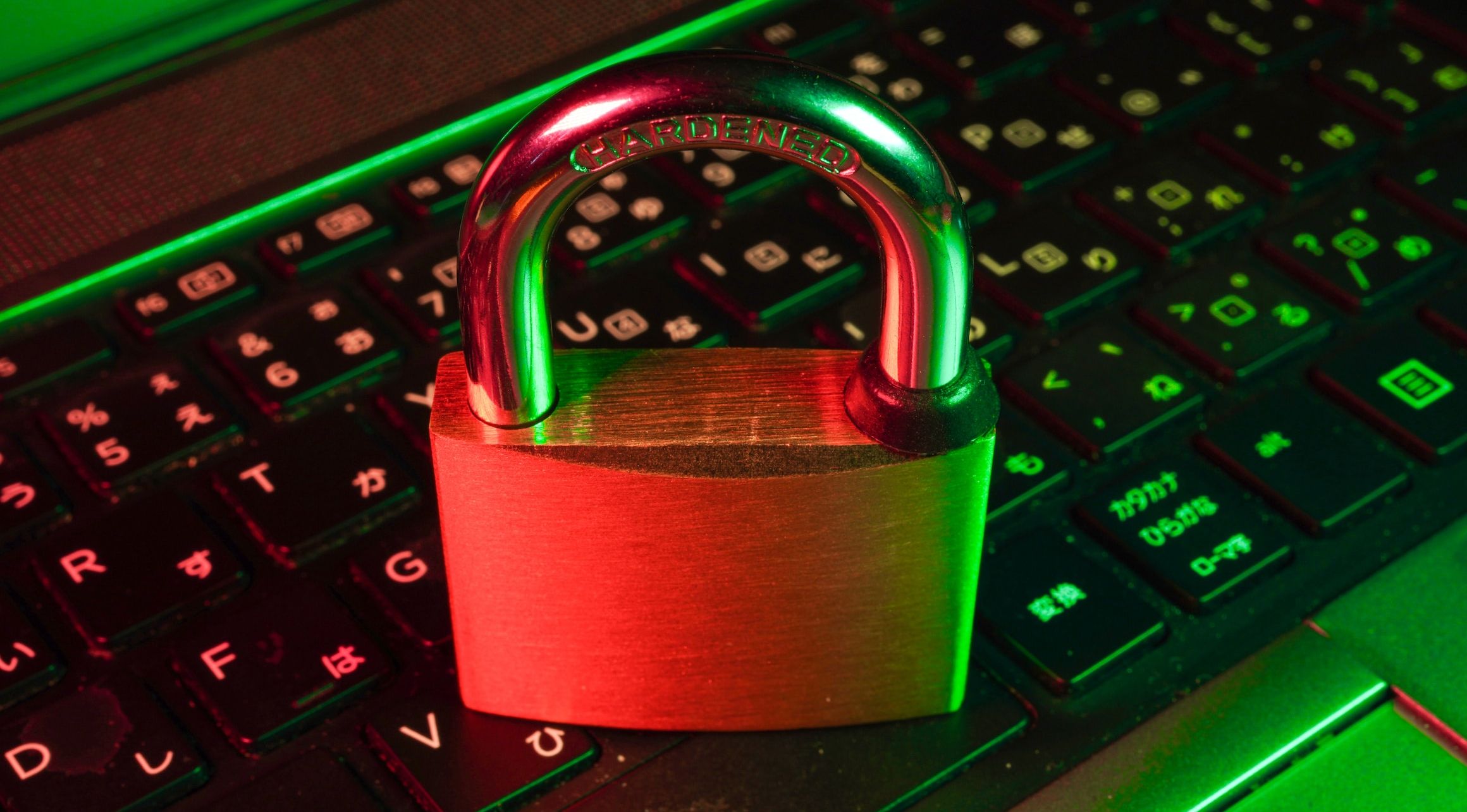 image of padlock sat on laptop keyboard under red and green lighting