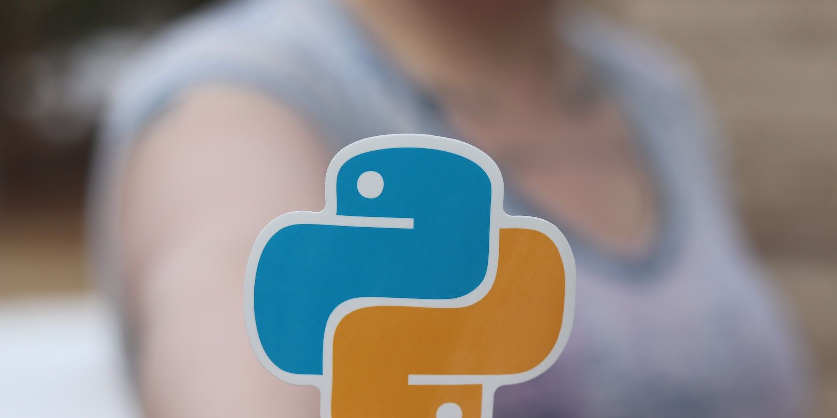 A person holding an orange and blue Python sticker