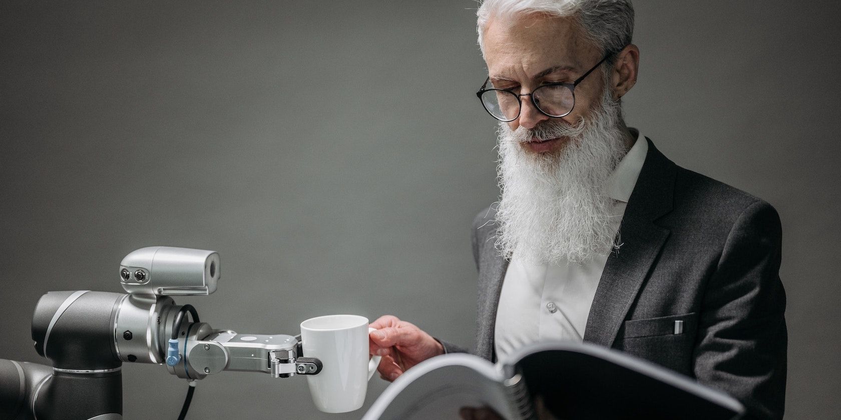 Old Man Reading and Getting Cup from Robot Hand