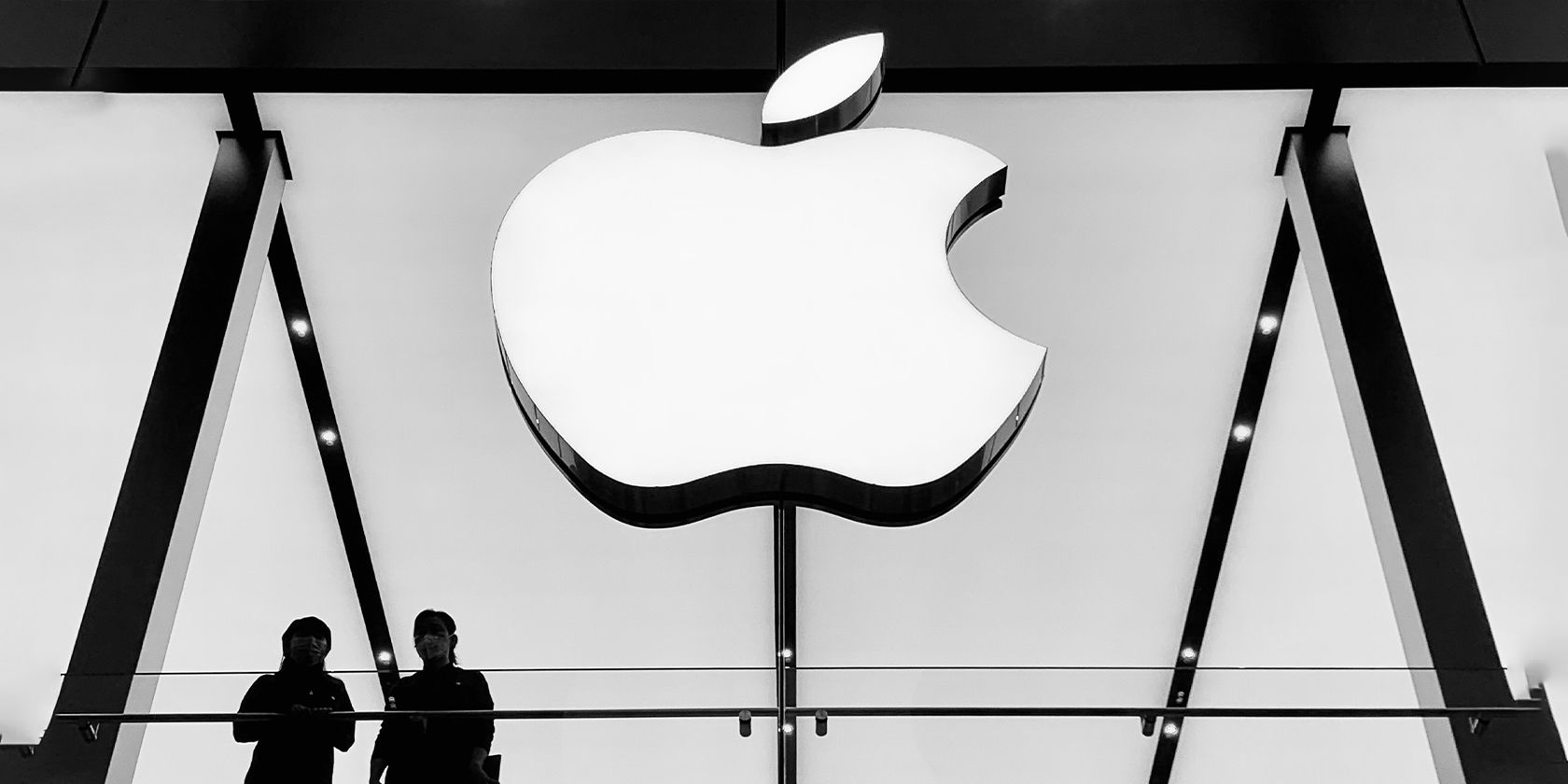 Two people in front of an Apple logo