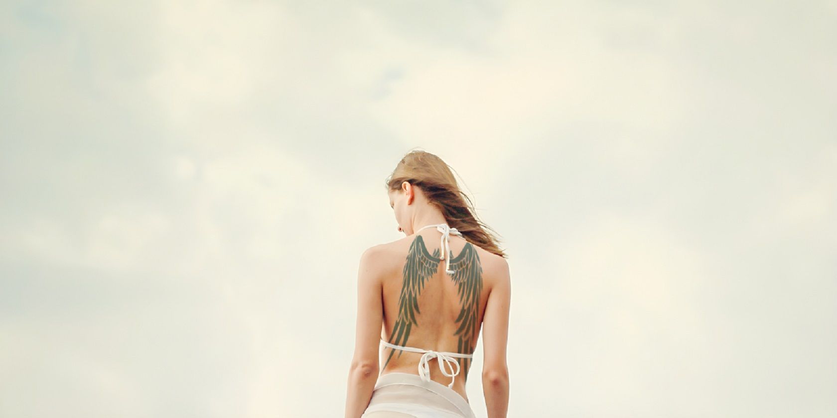 Woman in Swimsuit With Tattoo on Back