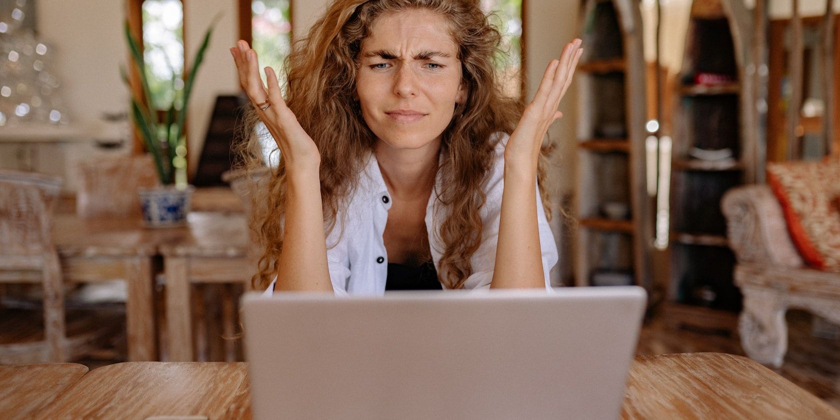 woman showing frustration on her face while using laptop