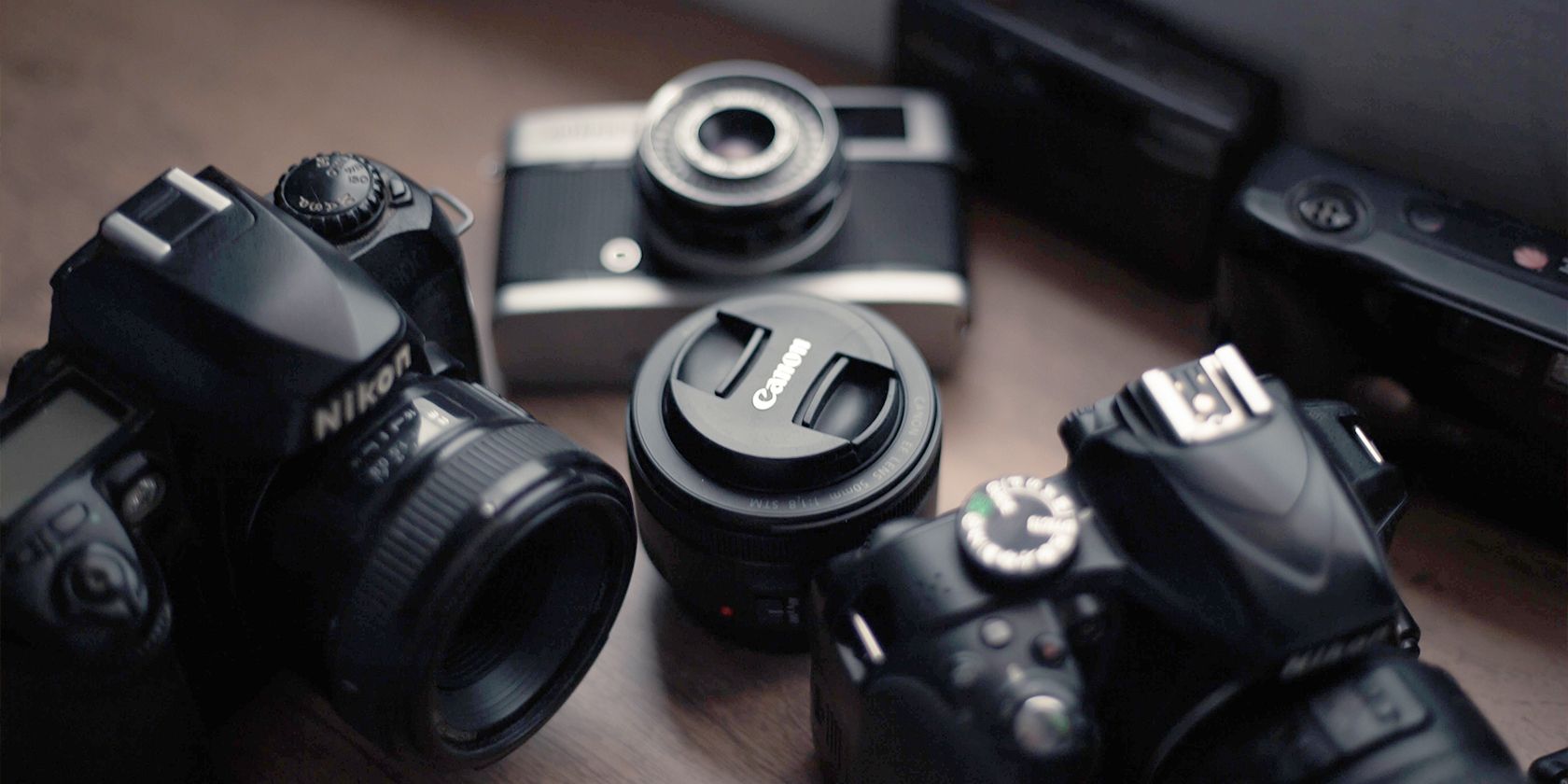 A Canon lens between two Nikon Cameras