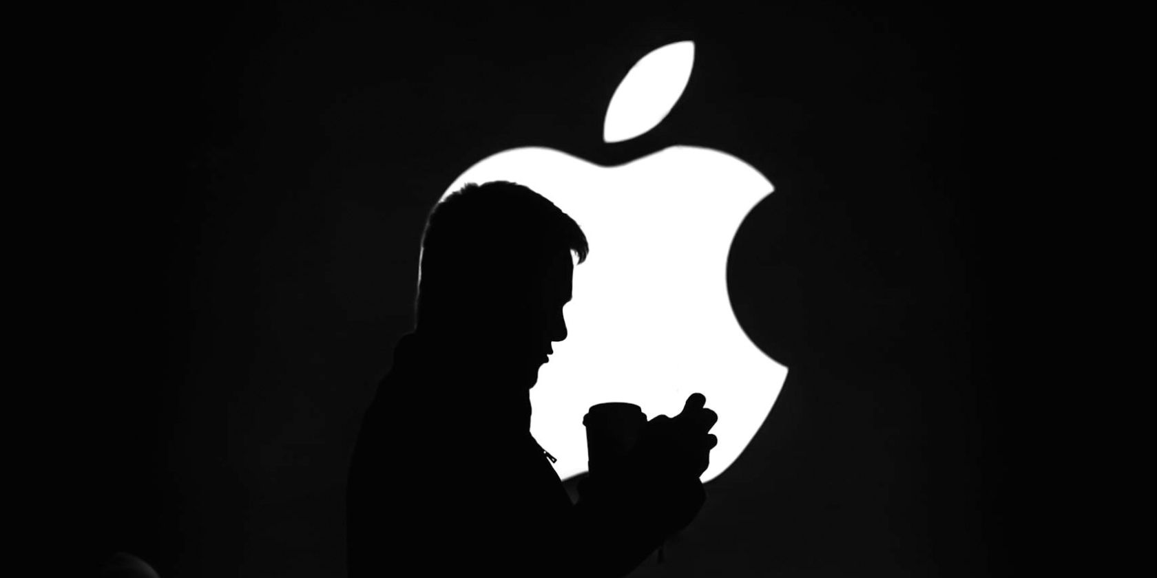 Shadow of a person standing in front of the Apple logo