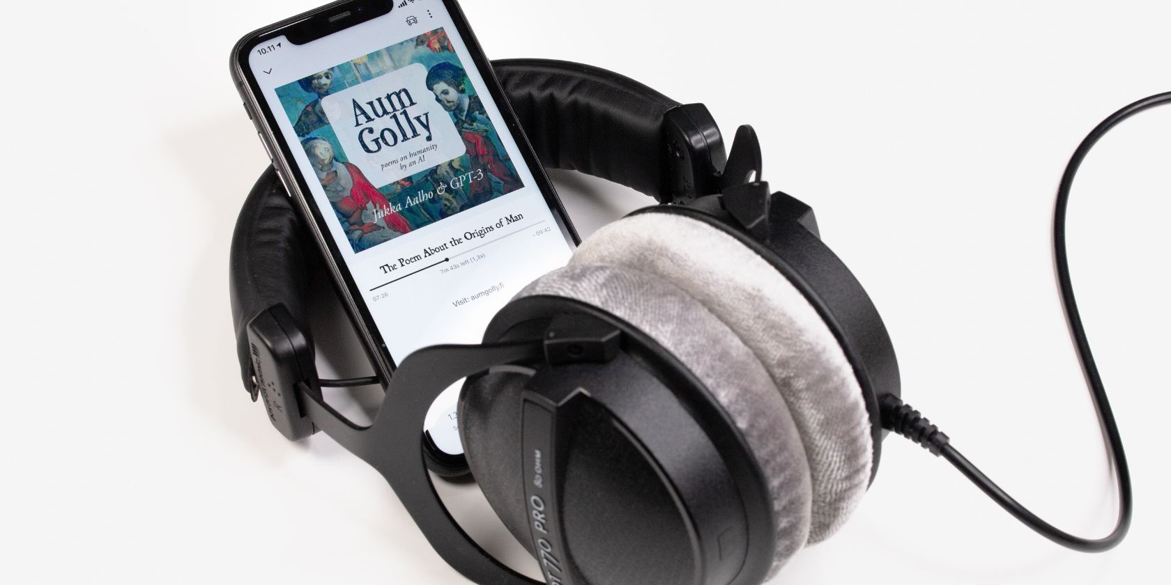 smartphone sitting within headphones playing audiobook