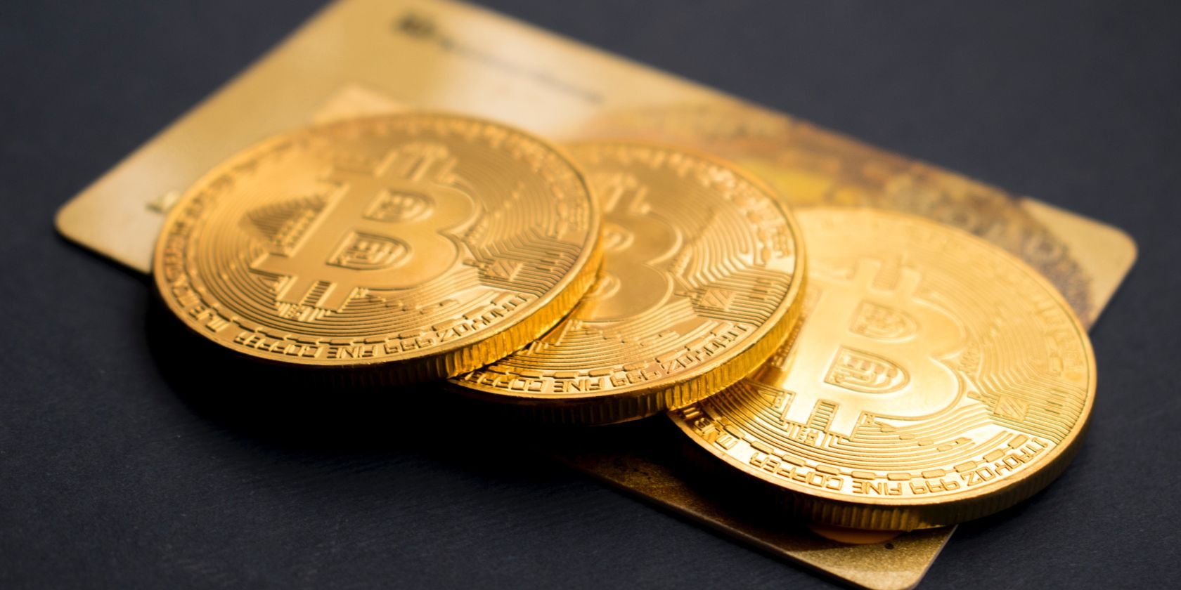 bitcoin coins lying on gold credit card