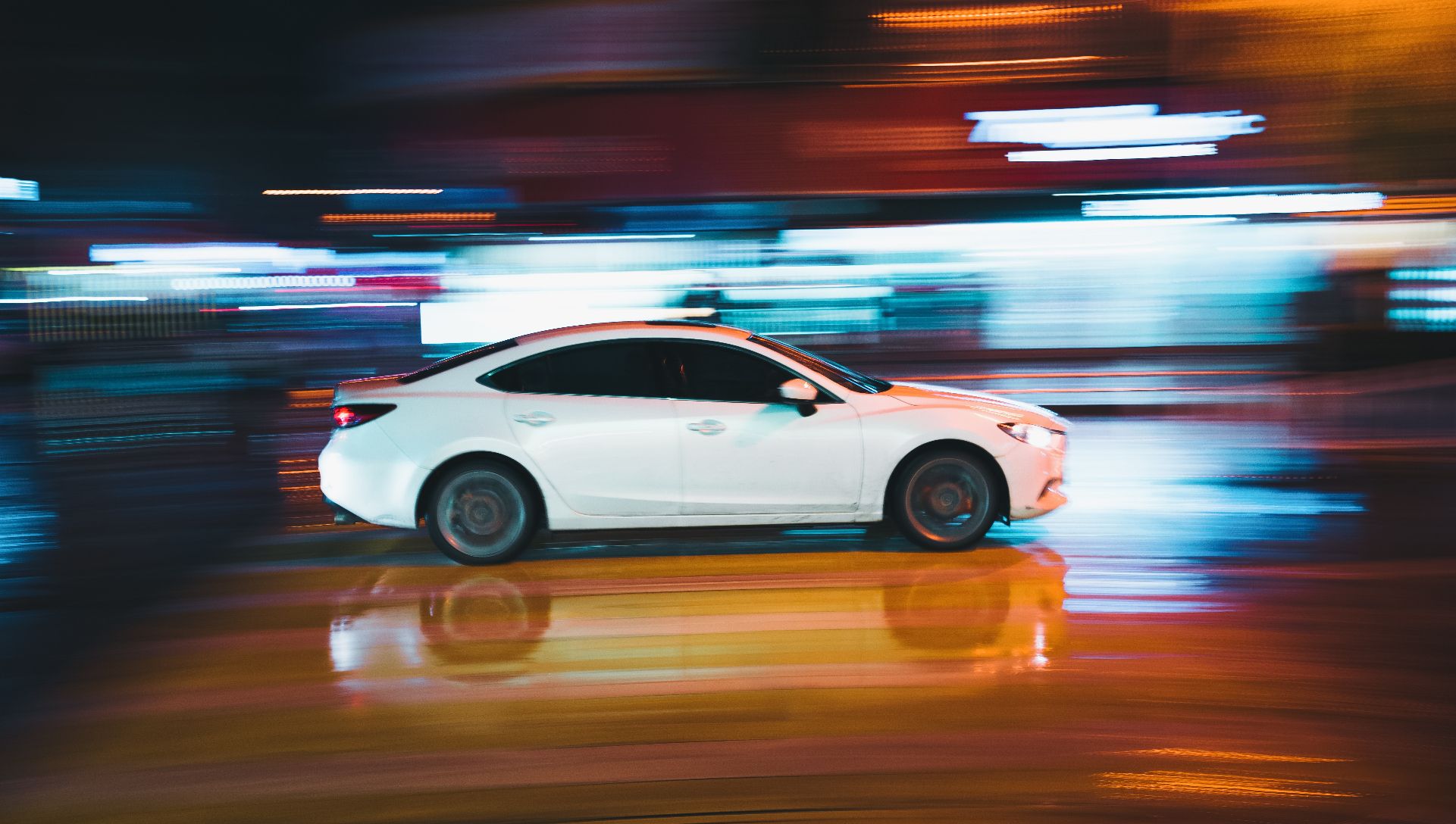 image of car driving at night with blurred background