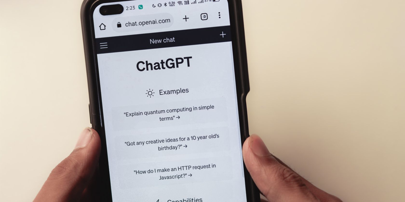 man holding a smartphone with official chatpgpt website open on it