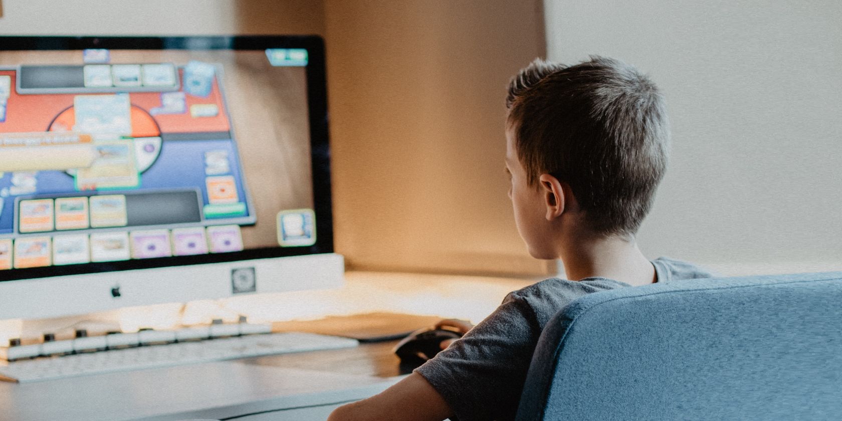 Child in Black Shirt Sitting in Chair Playing Video Game on Computer Photo
