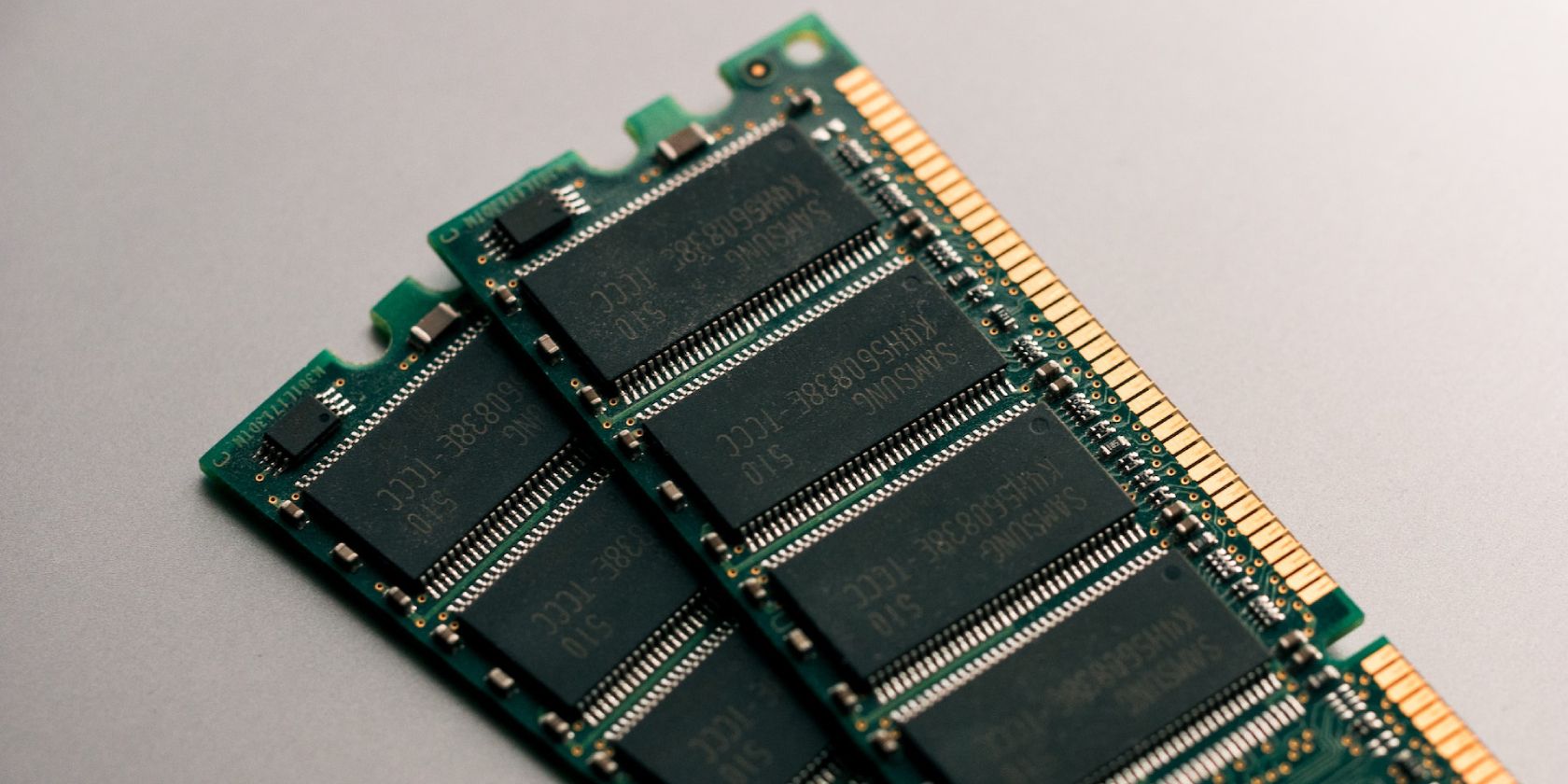 Two computer RAM sticks loosely stacked atop one another