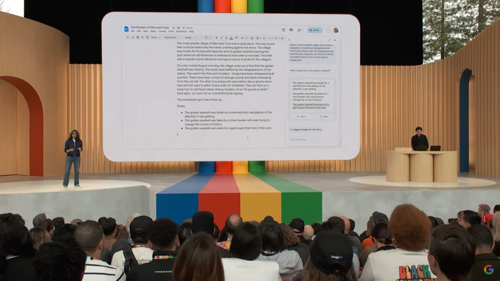 screenshot of Google I/O 2023 showing a woman and man on opposite sides of the stage with a screen between them showing an AI-assistant helping to write a story.