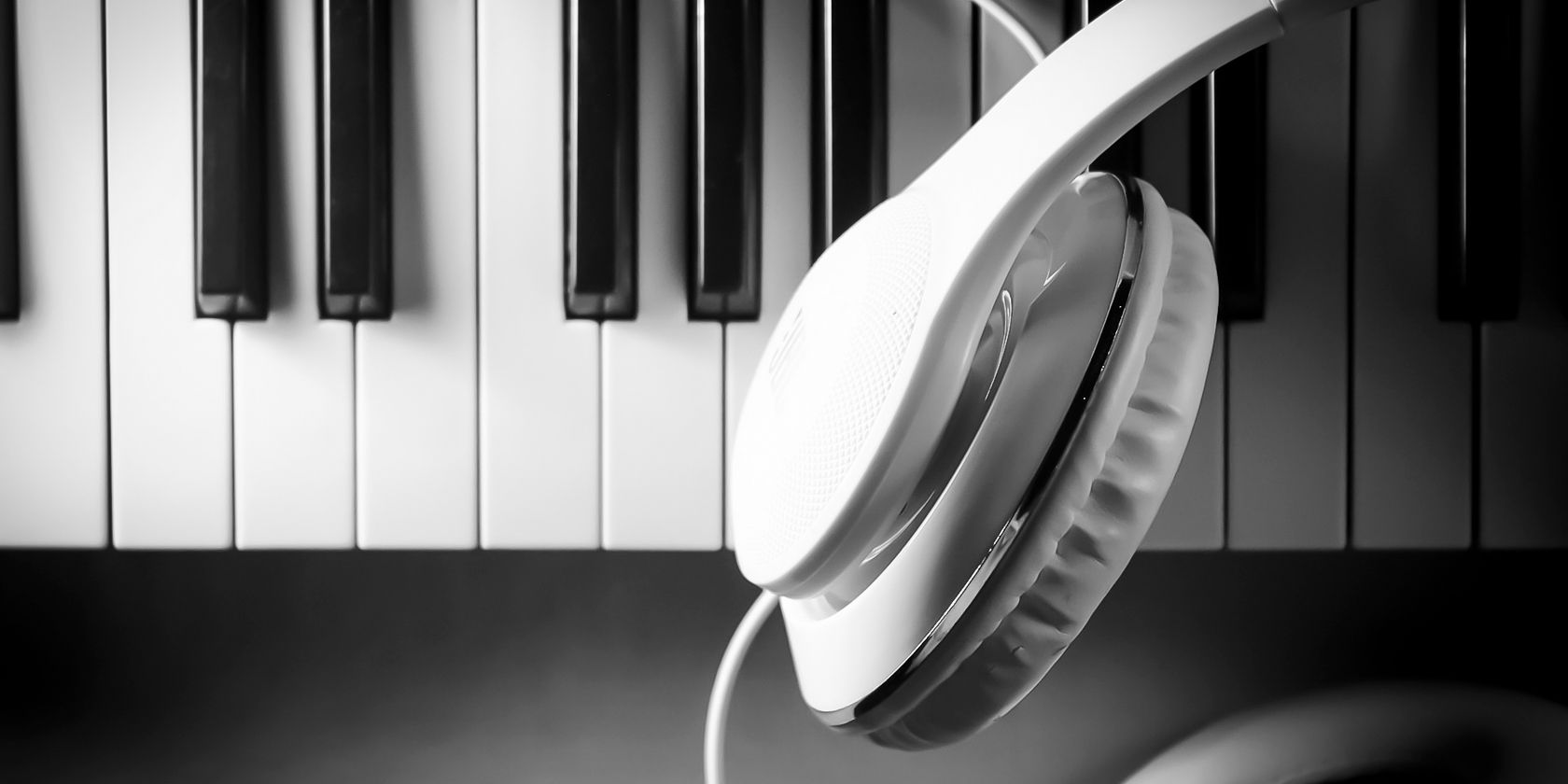 Headphones placed on top of a piano keyboard