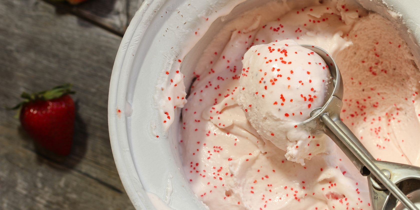Strawberry ice cream in an ice cream maker bowl