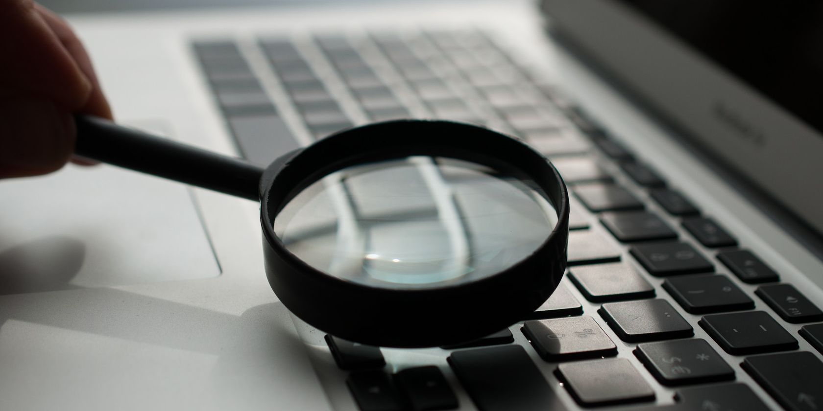 magnifying glass over a grey laptop keyboard