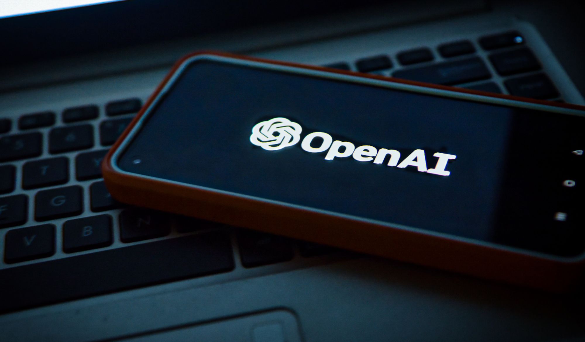 openai logo on smartphone place on laptop