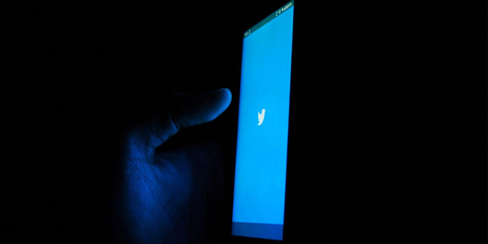 twitter app open on phone in dark room