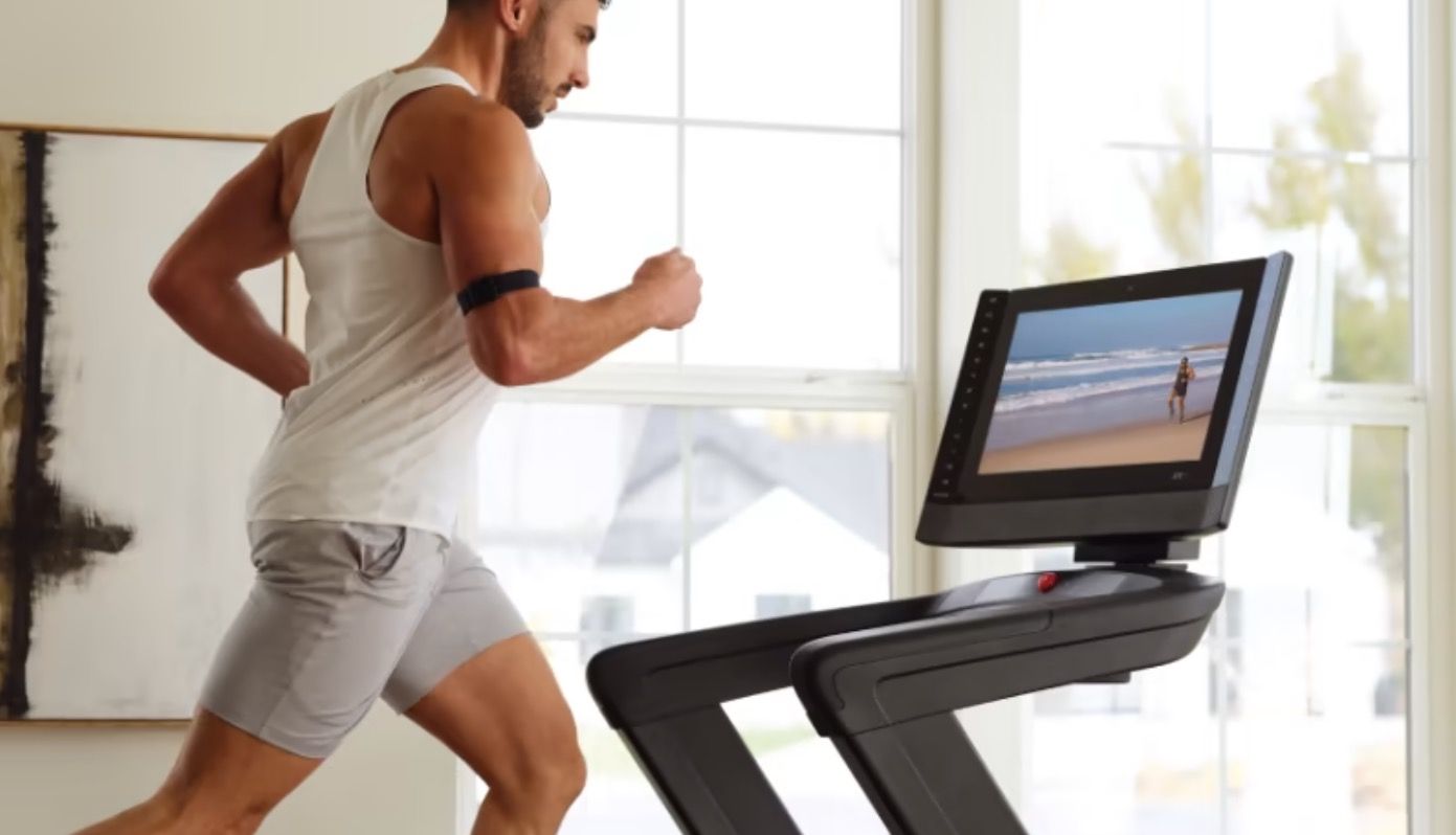 Man running on nordic track treadmill in home