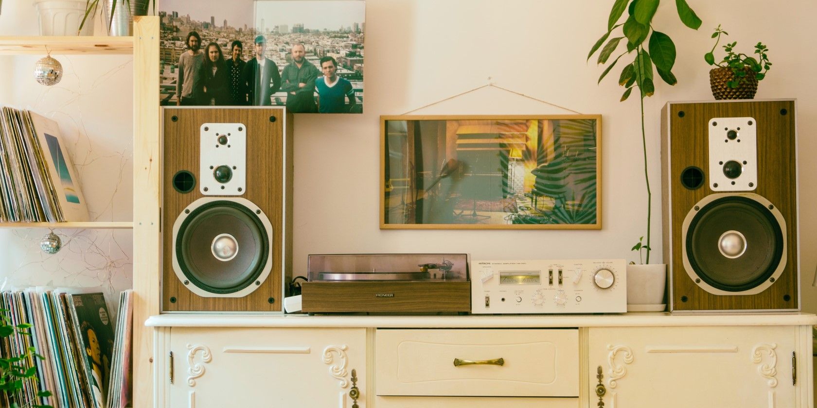 Một máy ghi âm và âm thanh nổi cũ trên tủ trang trí công phu gần các kệ album