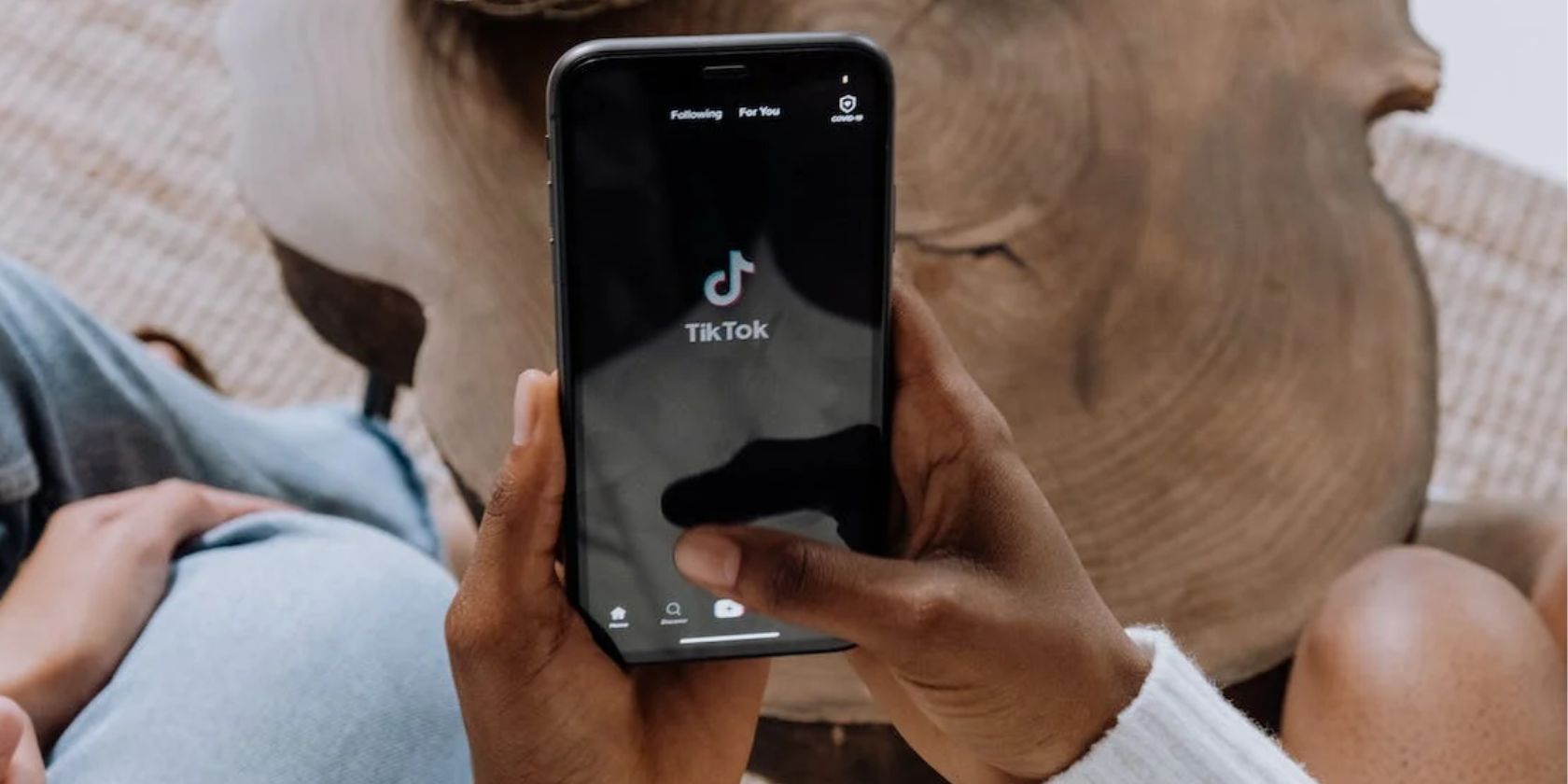 Person holding a smartphone with the TikTok app open on screen