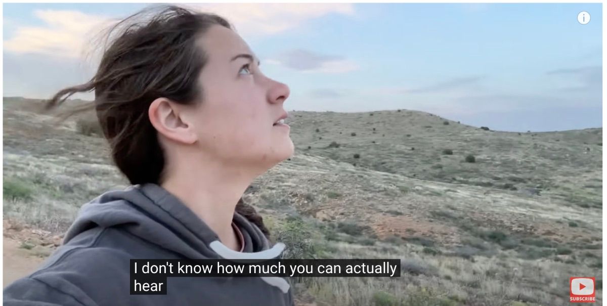 YouTube video with captions and mountains in the background