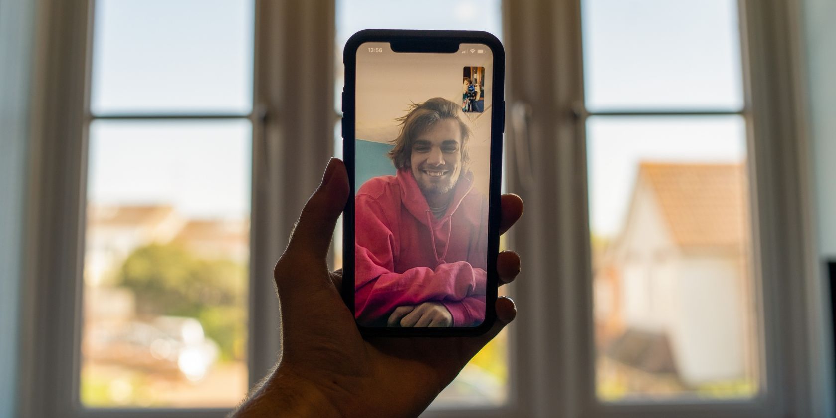 A man holding an iPhone while on a FaceTime video call