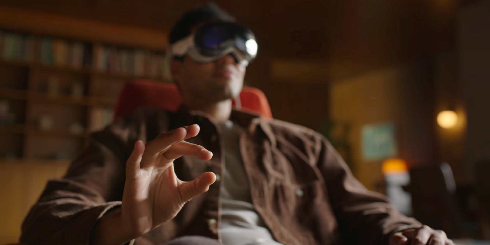 Young man wearing Apple's Vision Pro AR/VR headset, performing the pinch gesture