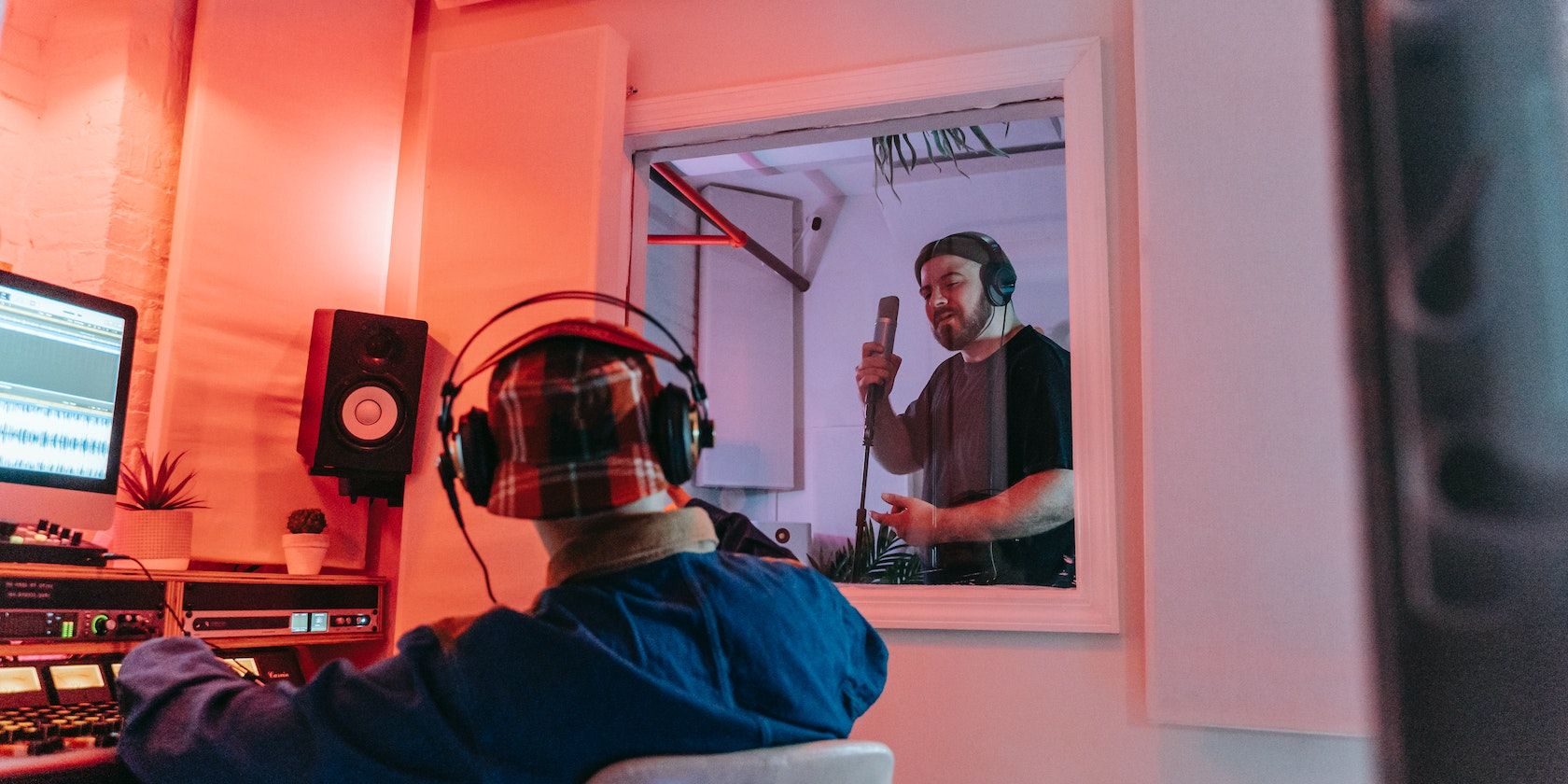 audio engineer works with man in recording booth