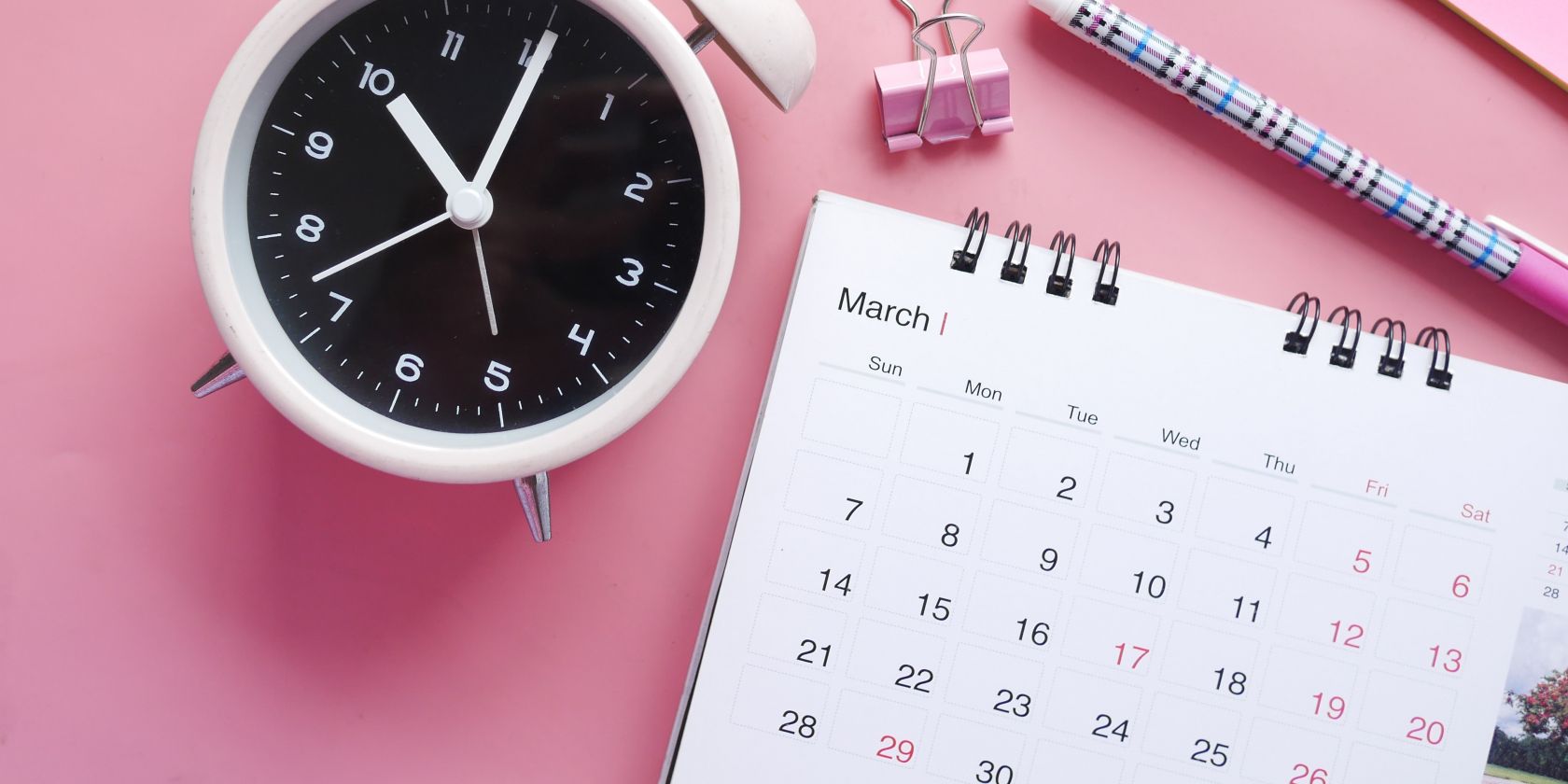 Photo of a calendar and an alarm clock together on a table