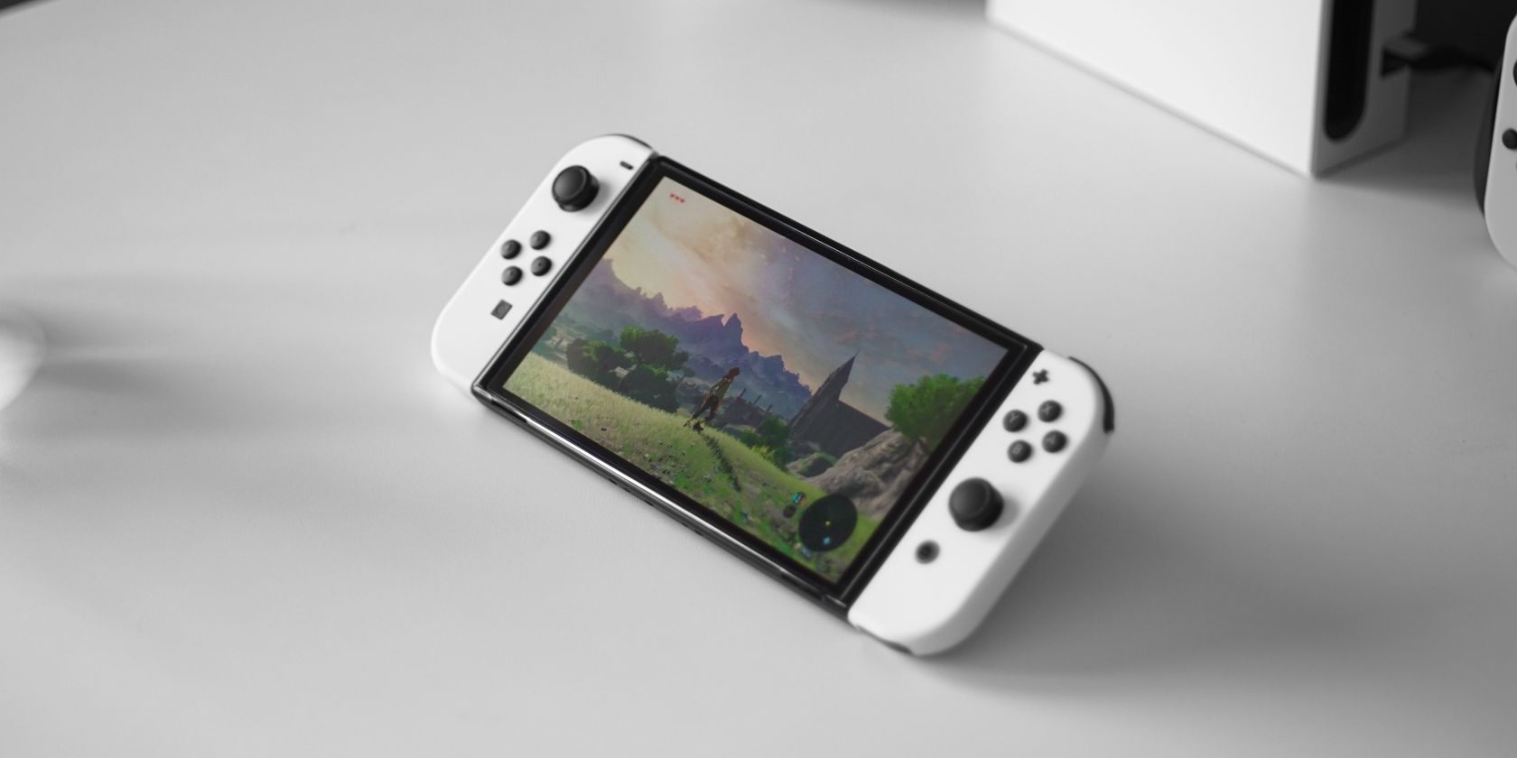 A photograph of a Nintendo Switch OLED console atop a white surface