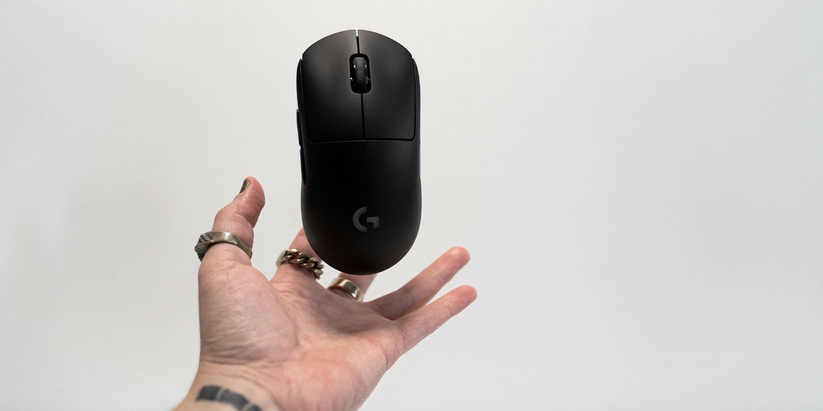 A person holding a black Logitech wireless computer mouse