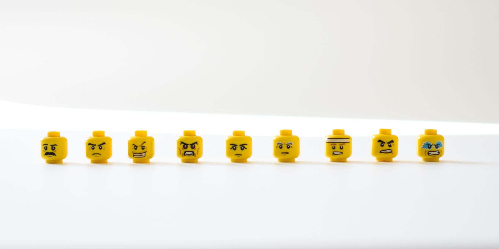 A series of lego figure heads in a row