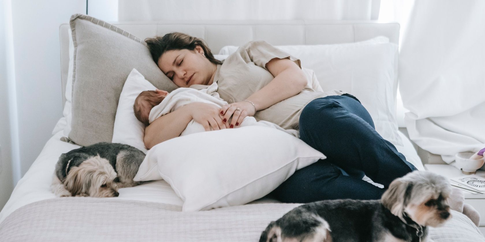 exhausted mom lying in bed with baby sleeping