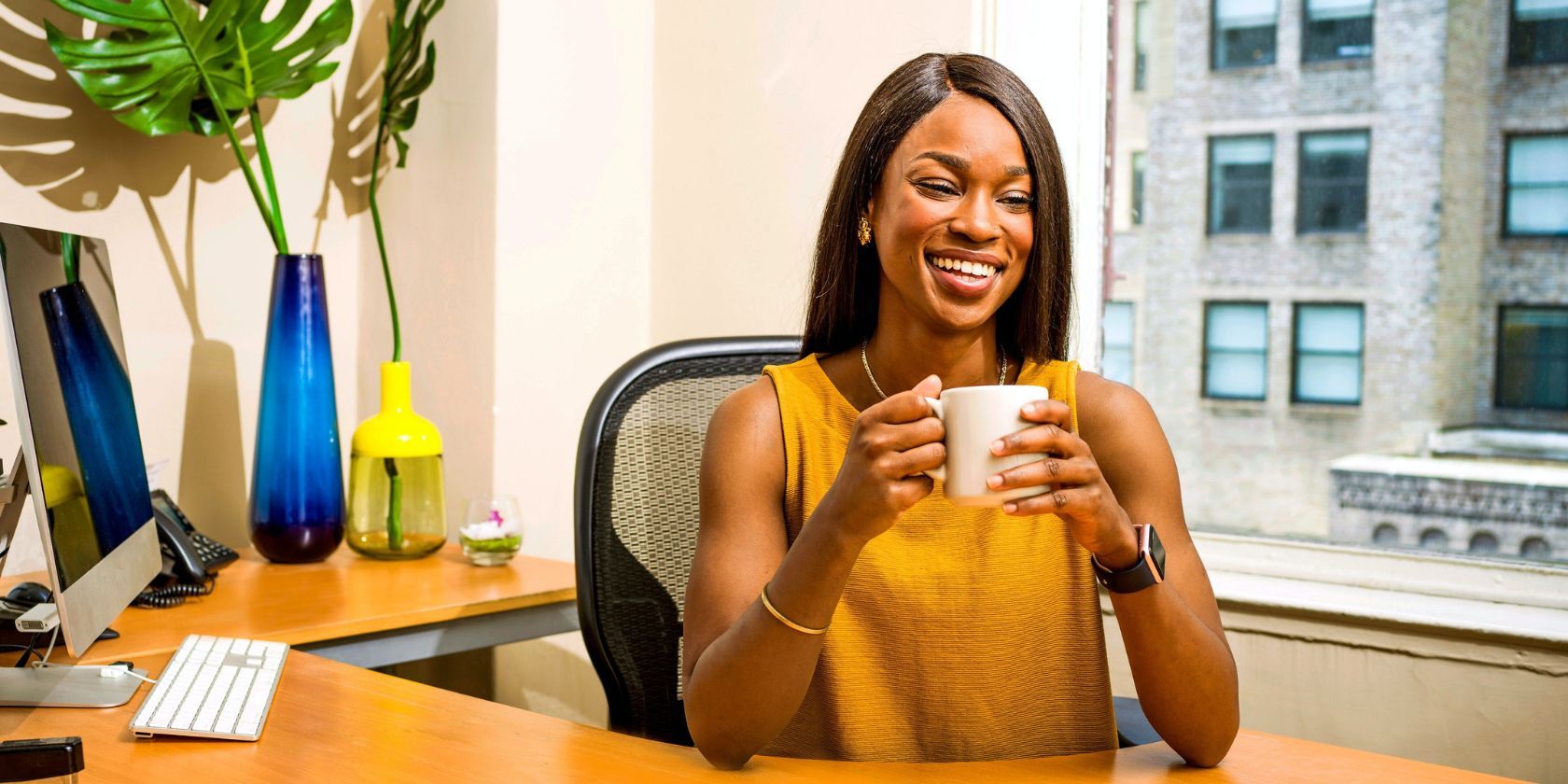 beautiful woman sitting at her office and holding a coffee cup 