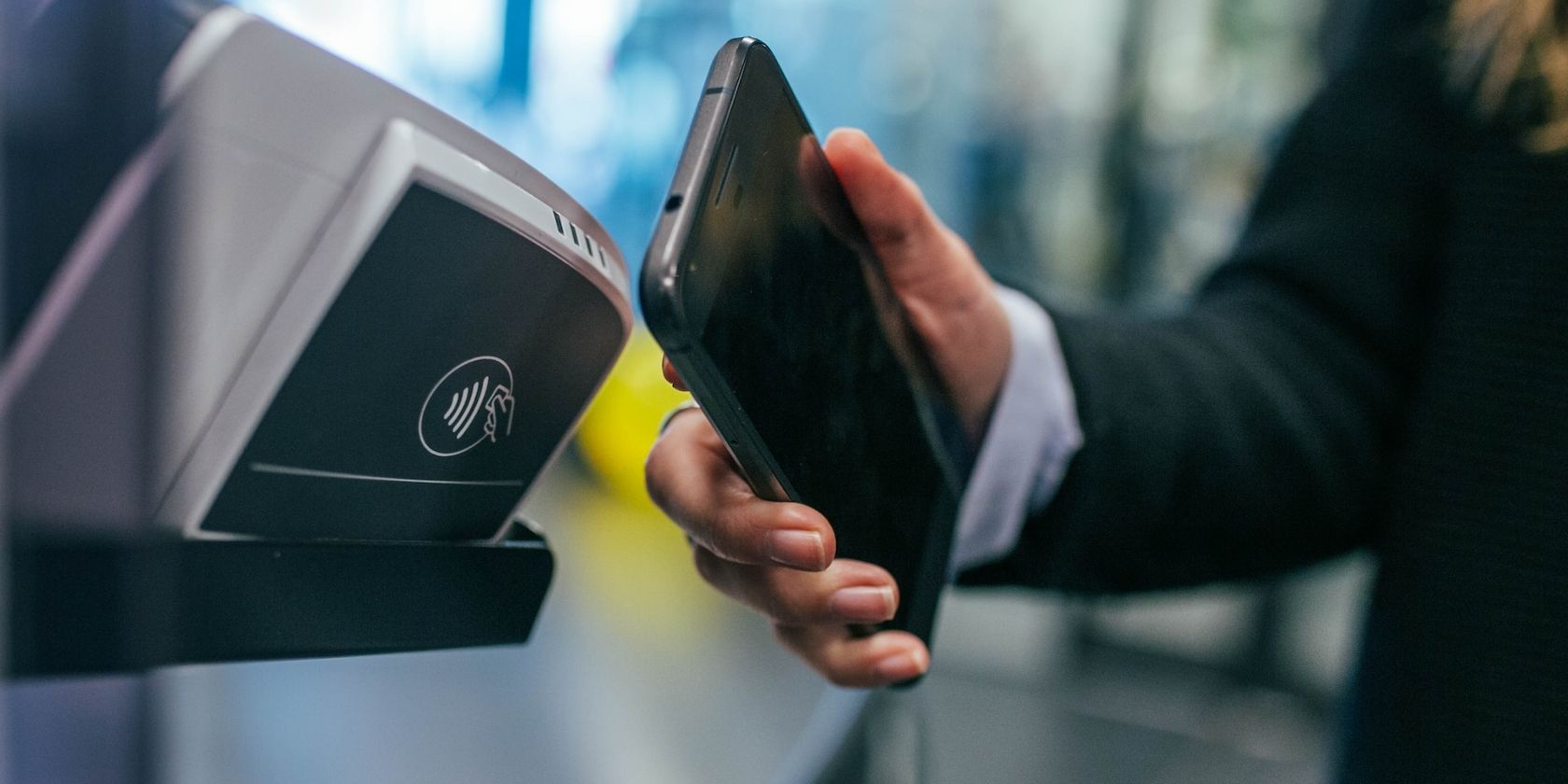 Person holding smartphone close to a payment terminal