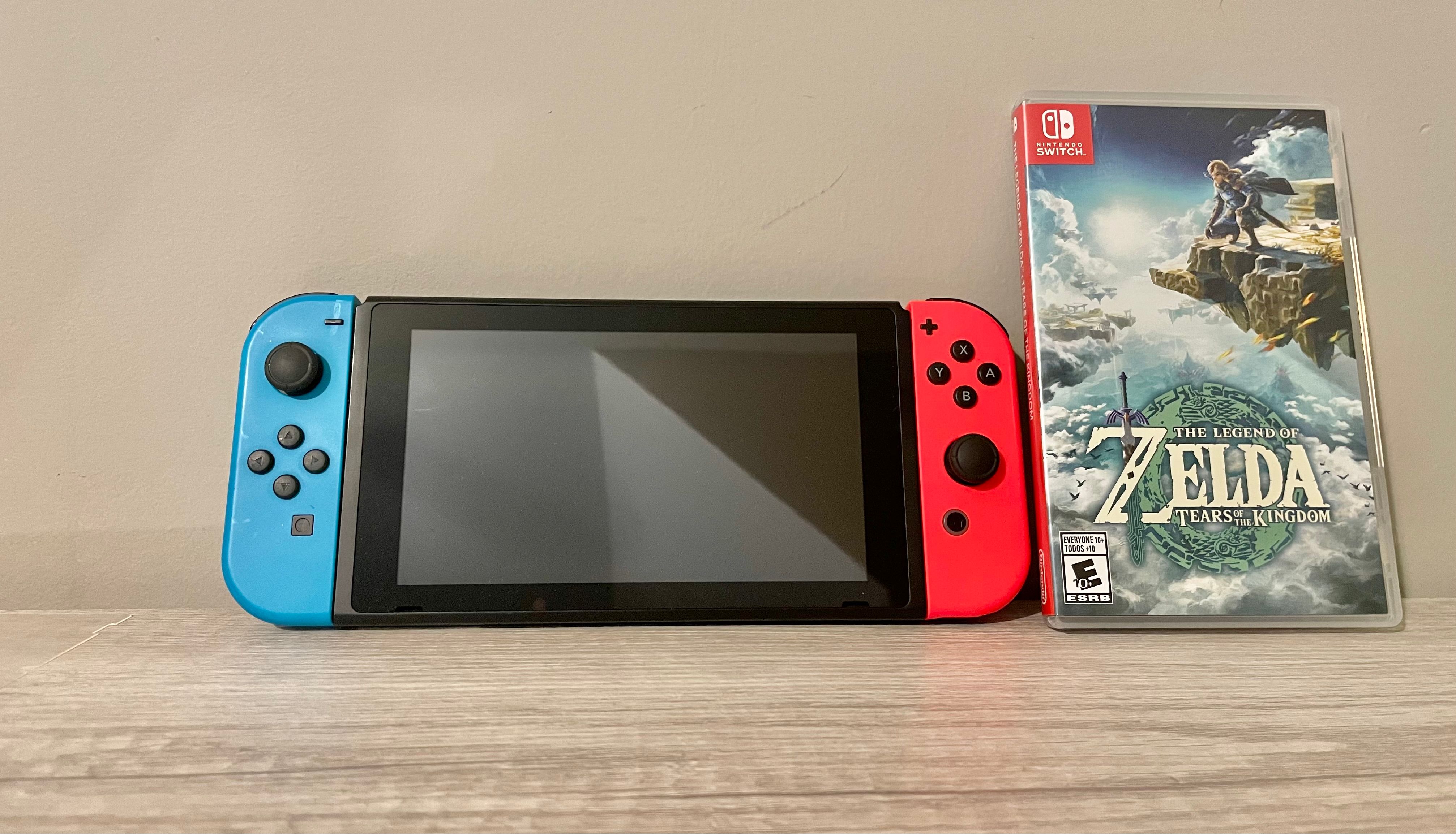 A photograph of a Nintendo Switch console next to a game case for The Legend of Zelda Tears of the Kingdom