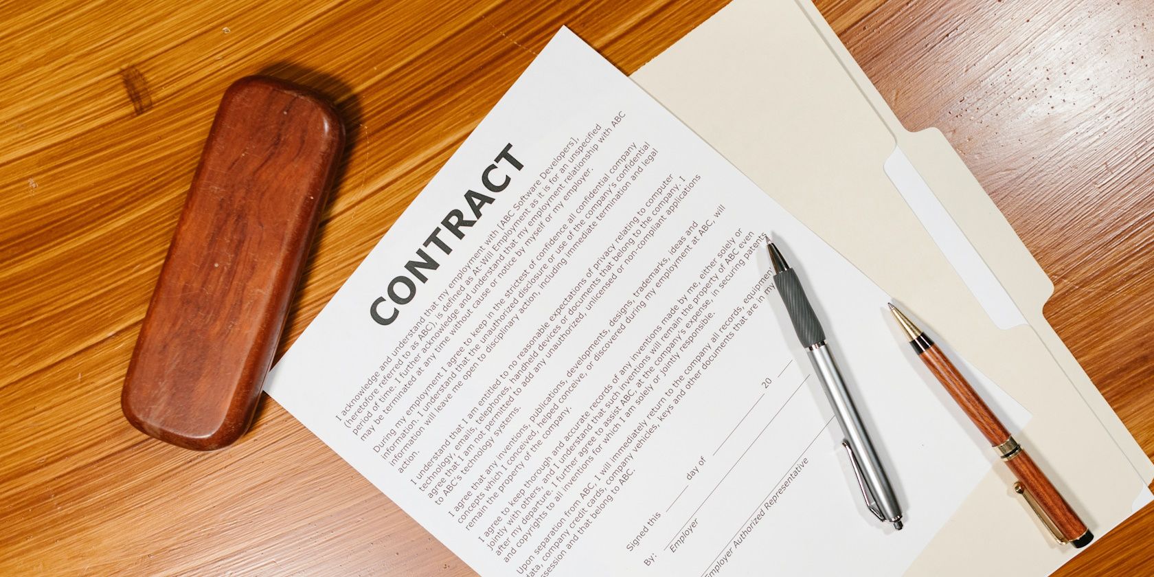 paper contract on wooden table with pen on top