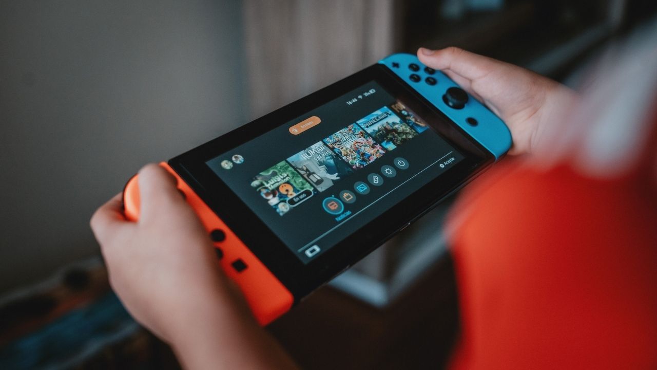 Uma fotografia de uma pessoa jogando um Nintendo Switch no modo portátil 