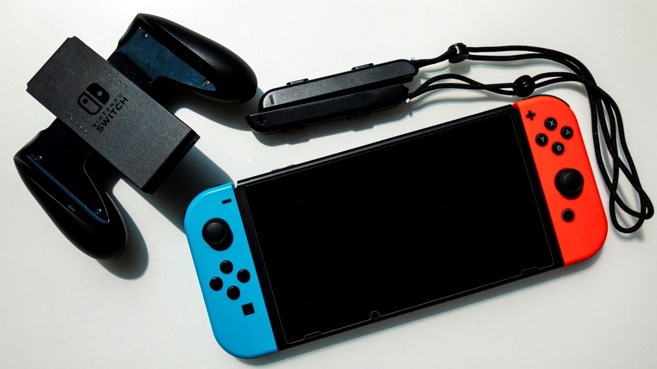Uma foto de um Nintendo Switch com acessórios e Joy Cons vermelhos e azuis 
